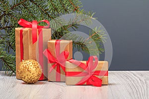 Gift boxes, toy ball and fir tree branch on gray background