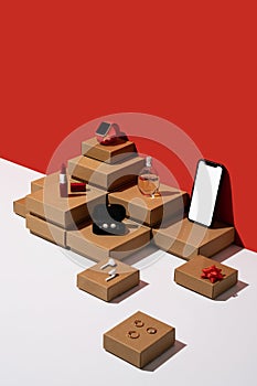 Gift boxes and women accessories organized neatly with smartphone mockup on red and white background