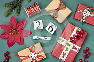 Gift boxes, wooden calendar with date December 26 on green background Boxing Day