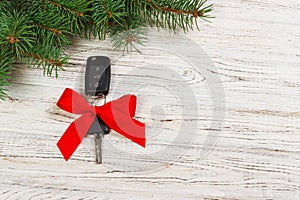 Gift for christmas car keys. Close-up view of car keys with red bow as present on wooden background