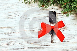 Gift for christmas car keys. Close-up view of car keys with red bow as present on wooden rustic vintage background