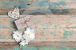 Gift with chrysanthemums and heart on old wooden turquoise background