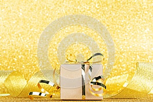 Gift close-up on gold ribbon background and sparkling background