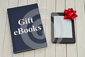 Retro old blue book on a desk with an ereader with gift bow photo