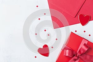 Gift, envelope and red heart on white table for greeting on Valentines Day. Flat lay.