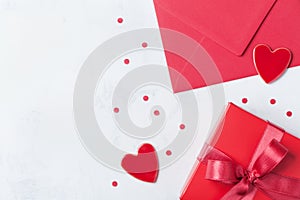 Gift, envelope and red heart on white table for greeting on Valentines Day. Flat lay. photo