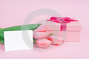 Gift with flowers tulips on a pink background for Valentine`s Day, for Mother`s Day, mock up