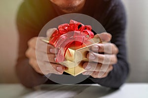 gift giving,man hand holding a gift box in a gesture of giving.blurred background,vintage effect