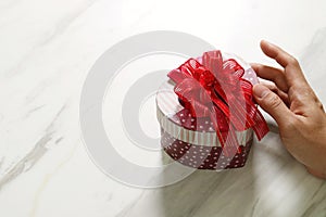 gift giving,man hand holding a heart shape gift box in a gesture