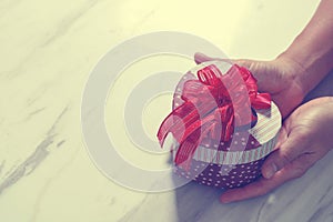 gift giving,man hand holding a heart shape gift box in a gesture