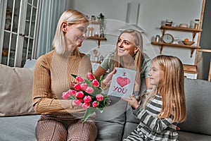Gift for grandmother. Mom and daughter congratulate grandmother on Women`s Day, Mother`s Day, happy birthday. The concept of
