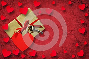 Gift with key and paper hearts on a red background. Copy space. Happy Valentines Day background.