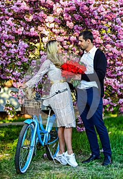 Gift with love. dog in retro bicycle date. romantic couple under sakura tree. couple in love with vintage bike. spring