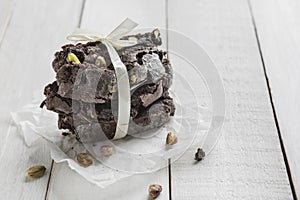 Gift packaging, Biscotti or Cantuccini chocolate with pistachios on a wooden table.