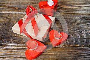 The gift is Packed tied with a red ribbon in the center of which lies a pendant in the shape of clogs with briliant