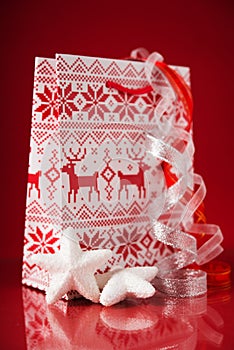 Gift packet with christmas ornaments on red background. Winter holidays.