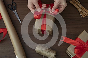 Gift preparation process, home crafts on a wooden background. Winter holidays