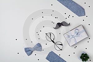 Gift or present box, bowtie, moustache, glasses and confetti for Happy Father day. Top view and flat lay