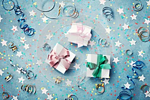 Gift or present box decorated colorful confetti, star and streamer on blue vintage table top view. Flat lay style. Christmas.