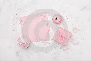 Gift or present box, pink paper blank and ranunculus flower on white table from above for wedding mockup or greeting card flat lay