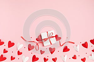 Gift or present box for Saint Valentine or Mother day decorated with paper red hearts top view. Flat lay festive card