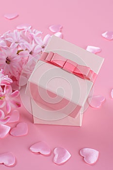 Gift or present box and stars confetti on pink table top view. Flat lay composition for birthday, mother day or wedding.