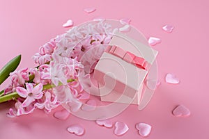 Gift or present box and stars confetti on pink table top view. Flat lay composition for birthday, mother day or wedding.