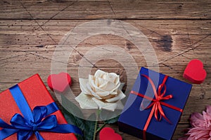 Gift or present boxes with red and blue bow ribbon, hearts and flowers on wooden background for Valentines day. copy space top vie