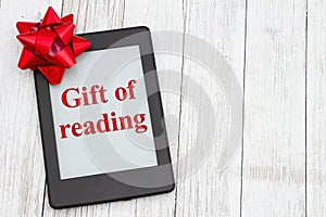 The gift of reading with an ereader with gift bow on an old weathered table photo