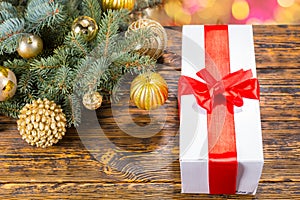 Gift with Red Bow on Table with Festive Pine Bough