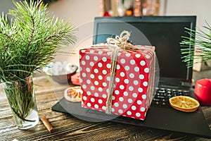 Gift red box with white polka dots on the laptop. Purchase discounts for Christmas and new year in online stores