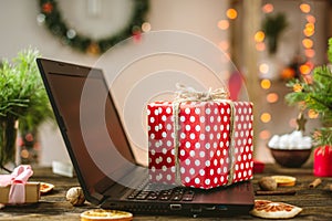 Gift red box with white polka dots on the laptop. Purchase discounts for Christmas and new year in online stores