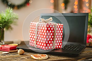 Gift red box with white polka dots on the laptop. Purchase discounts for Christmas and new year in online stores