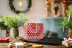 Gift red box with white polka dots on the laptop. Purchase discounts for Christmas in online stores on new year`s eve