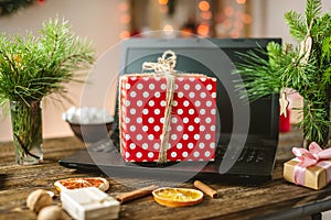 Gift red box with white polka dots on the laptop. Purchase discounts for Christmas in online stores on new year`s eve