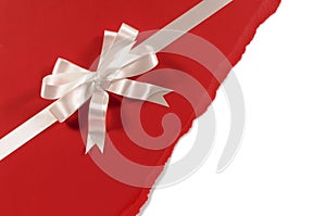 Gift ribbon bow with untidy torn red paper background, white copy space