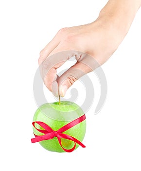 Gift ribbon tied with green apple and hand