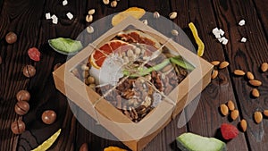 A gift set of various nuts and dried fruits on a wooden surface.