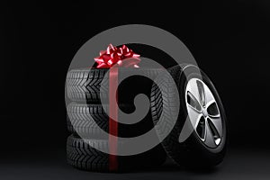 Gift set of wheels with winter tires on black background