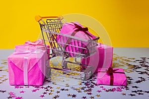 Gift shopping, shopping cart is full of gift boxes. New year`s shopping concept