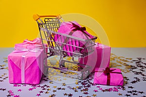 Gift shopping, shopping cart is full of gift boxes. New year`s shopping concept