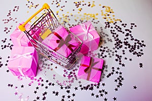 Gift shopping, shopping cart is full of gift boxes. New year`s shopping concept