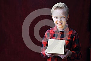 Gift, smiling happy boy with a Christmas present.