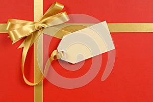 Gift tag or label, red background, gold ribbon bow, copy space, Christmas present or gift