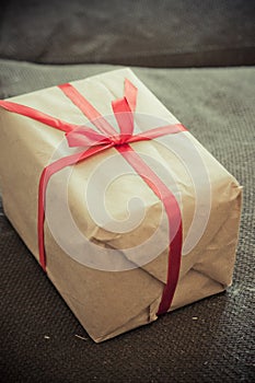 Gift wrapped in craft paper with red satiny ribbon