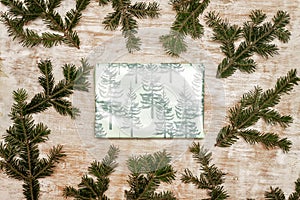 A gift wrapped in festive Christmas paper on a wooden background
