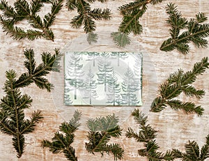 A gift wrapped in festive Christmas paper on a wooden background