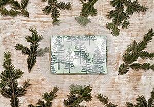 A gift wrapped in festive Christmas paper on a wooden background