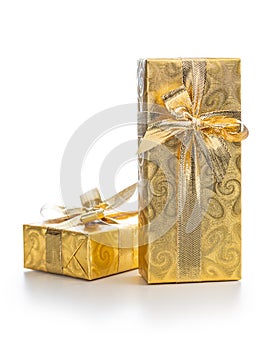 Gift wrapped in gold foil. Christmas present with gold ribbon isolated on white background