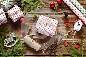 Gift wrapping. Christmas composition with present box, packing paper, festive decoration and fir tree branch. Preparation for holi